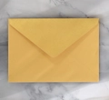 Close-up of a golden pearlescent paper envelope with V-flap on a marble background - Gold Long
