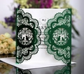 Detail of laser-cut dark green wedding invitation with intricate bird and lace patterns - Reflective Green