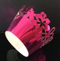 Macro detail of laser-cut sunflower pattern on metallic pink cupcake wrapper liner - Reflective Rose Red
