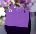 Purple laser-cut butterfly wedding place cards with heart motifs on black reflective surface - Dark Purple