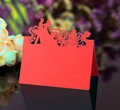 Close-up of laser-cut red wedding place card with heart and wedding silhouette detail - Red