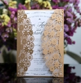 Detail of laser-cut floral wedding invitation with golden outer cover and elegant white insert - Beige Gold