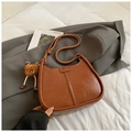 Retro bruine halfmaanvormige schoudertas in leer met een stijlvolle pluche hanger - Bruin met hanger