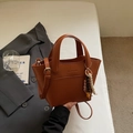 Bolso tipo cubo en cuero marrón caramelo con asas de mano y colgante de cuentas decorativo - Marrón con colgante