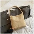 Minimalist beige corduroy bucket bag with silver chain detail on a neutral bed background - Khaki