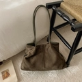 Detail of a large dark brown suede tote bag with slim green straps in a cozy room setting - Suede-look Green Without Pendant
