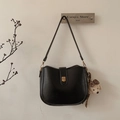 Detail of black semi-circular bucket bag with golden buckle and plush puppy charm - Black With Bear Pendant