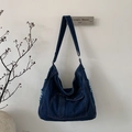 Detail van donkerblauwe denim hobo-tas met trendy gerafelde franjes en handige vakken - Donkerblauw