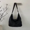 Detail van de vintage zwarte denim hobo tas met onafgewerkte randen en handig buitenvak - Zwart