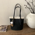 Detail of black suede tote bag with white faux shearling trim and brown glove charm - Black