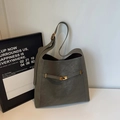 Bolso saco minimalista en gris verdoso con herrajes dorados y textura de gamuza - Verde