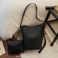 Dettaglio borsa a secchiello nera in pelle martellata con pochette e ciondolo a pompon - nero con ciondolo
