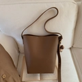 Detail einer braunen Beuteltasche mit Litschi-Muster und süßem Plüschbär-Anhänger - Braun (Mit Anhänger)