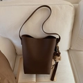 Detailansicht der dunkelbraunen Eimertasche mit Litschi-Muster und Bärenanhänger - Kaffee (Mit Anhänger)