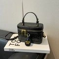 Chic black quilted box bag with glossy finish and gold zipper details on a book - Black without Pendant