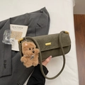 Detail of vintage olive green leather underarm bag with cute plush puppy charm - Green with Pendant