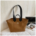 Brown suede tote bag with black handles and silver oval detail in an office setting - Yellow Brown
