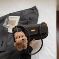 Close-up of retro brown underarm bag with gold clasp and plush dog accessory - Coffee with Pendant