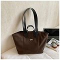 Detailed macro view of dark brown suede tote bag featuring silver metal nameplate and straps - Brown