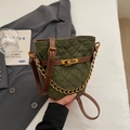 Dettaglio borsa a secchiello trapuntata verde scuro con catena dorata e chiusura a vite - Verde