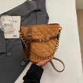 Dettaglio della borsa a secchiello in camoscio trapuntato marrone con chiusura dorata - Cachi