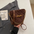 Dettaglio borsa a secchiello trapuntata marrone con catena dorata e fibbia vintage - caffè