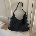 Détail d'un sac fourre-tout noir en nylon avec fermetures éclair sur canapé - Noir