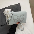 Detail of light blue crossbody bag with silver rivets bow and pearl lace charms - Blue