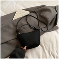 Bolso tipo cubo negro minimalista con correas dobles sobre fondo de traje gris - Negro sin Colgante