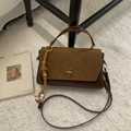 Close-up of brown leather handbag with suede flap, metal twist lock and bead charm accessory - Suede Brown