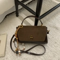 Detail of vintage brown leather handbag with suede flap and beaded tassel on white carpet - Suede Coffee