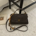 Close-up of a vintage dark brown tote bag with metal clasp and woven bead charms - PU Coffee