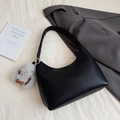 Minimalist black pebble leather crescent shoulder bag with a plush bunny charm - Black with Pendant