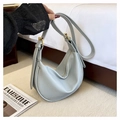 Detail view of grey-blue dumpling hobo bag with pebbled leather texture and gold metal buckles - Blue