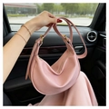 Detailed close-up of pink crescent bag with lychee grain leather and golden hardware - Pink