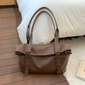 Gros plan d'un sac cabas en cuir grainé marron avec sangles à boucles métalliques réglables - Marron
