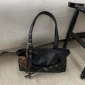 Detalle del bolso tote de cuero PU negro con ojales metálicos y dije de sombrero a cuadros - Negro con colgante