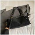 Bolso tote negro minimalista con ojales metálicos dorados distintivos en la correa - Negro