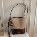 Detailansicht der Vintage-Beuteltasche mit Kontrastnähten und dekorativen Anhängern - Khaki mit Anhänger