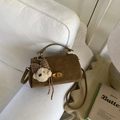 Detalle de bolso bandolera de ante marrón con cierre de metal y amuleto de osito de peluche - PU Marrón
