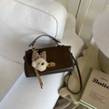 Detalle del bolso vintage marrón oscuro con solapa mate y amuleto de perro suave - Gamuza Café