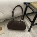 Detail of dark brown suede Boston bag with silver zippers on a white plush rug - Style Without Charm / Brown