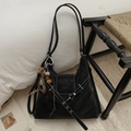 Détail d'un sac cabas noir avec surpiqûres blanches et breloque coeur sur une chaise - Avec Pendentif / Noir