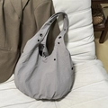 Minimalist grey nylon crescent tote bag with metal grommets on a soft background - Gray