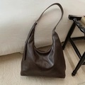 Makro-Detail der dunkelbraunen Hobo-Tasche mit matter Kunstleder-Textur und dekorativen Nähten - Braun