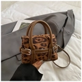 Detailed close-up of leopard print mini handbag with brown leather straps and metallic buckle - Leopard Brown