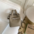 Detailed shot of khaki lychee grain leather bucket bag with silver metal swivel lock - Gray