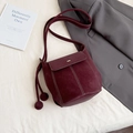 Burgundy faux suede bucket bag with contrast stitching and ball tassel charms - Red