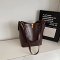 Bolso tipo cubo minimalista en cuero marrón oscuro con cierre dorado y bandolera - café