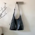 Detalle del bolso tote negro de cuero PU con pespuntes blancos y hebilla metálica plateada - Negro